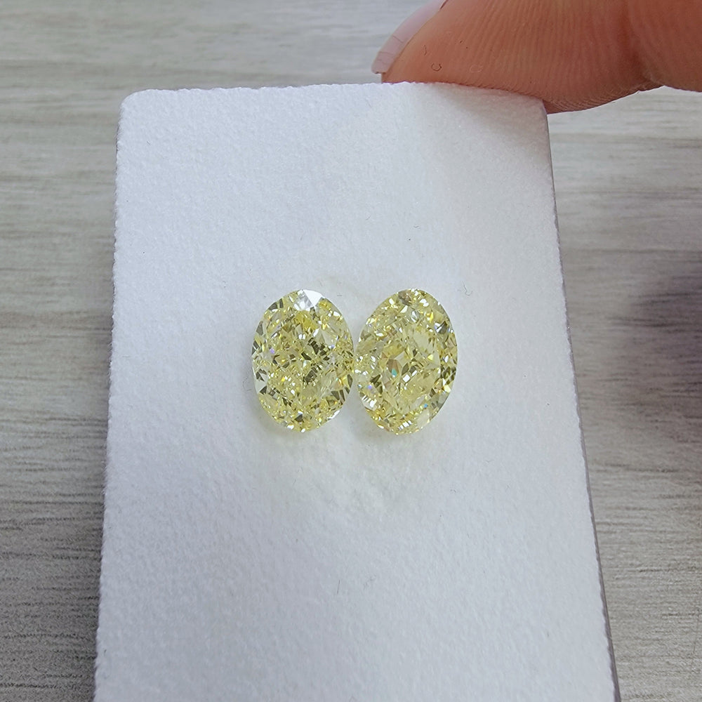 3.00ct & 3.00ct Fancy Light Yellow Oval Diamonds GIA